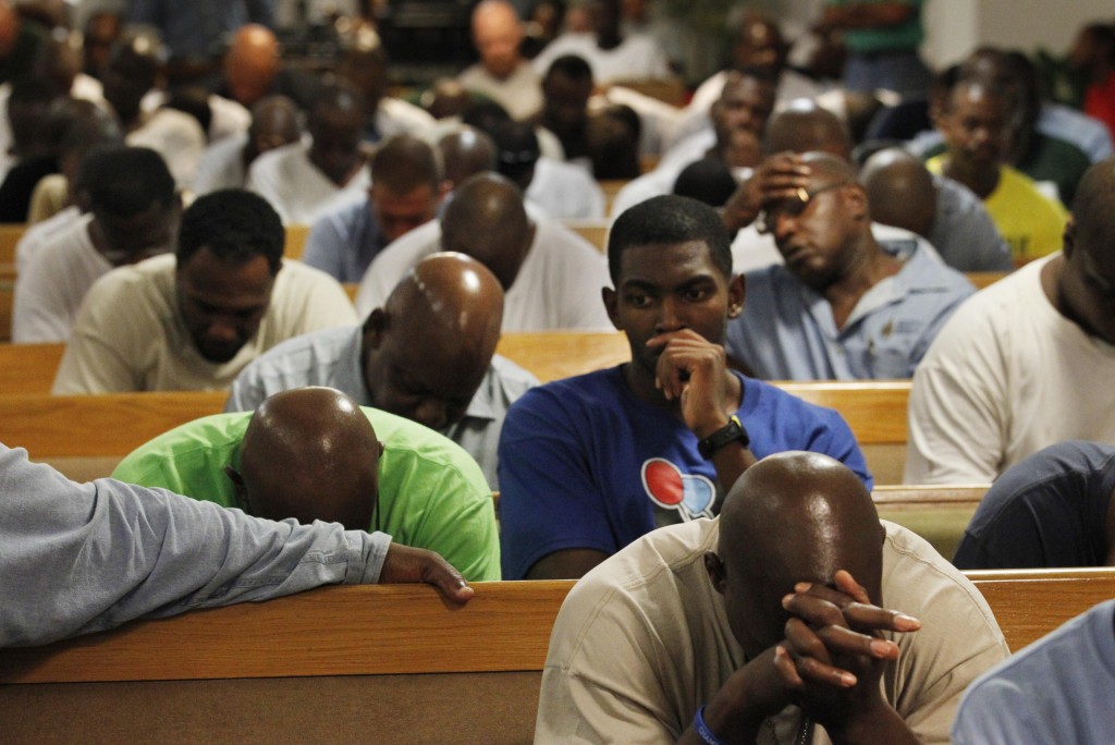 Inmates pray together at the Louisiana State Penitentiary in Angola, La., after watching the screening of the documentary 'Serving Life,' by director Lisa R. Cohen, Thursday, July 21, 2011. The film is about the volunteer hospice work done by inmates for inmates dying in the prison. (AP Photo/Gerald Herbert)