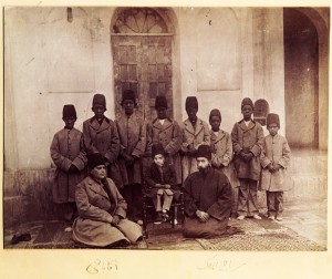 This photo was probably taken by Masoud Mirza Zell-e-Soltan (1850-1918), governor of Isfahan (1872-1907), and the eldest son of Nasser al-Din Shah. Zell-e-Soltan’s son Bahram Mirza sits in the middle on a chair accompanied by two members of his court (Reza Qoli Khan, private secretary in the right and Aqabaji eunuch chief in the left) sitting on the right and eight African eunuchs. The design of the jacket and hat of the Africans slaves could be considered a type of ethnic segregation. Photograph: Farhad and Firouzeh Diba Collection of Qajar Photographs