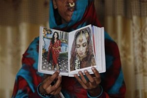 In this photo taken on Jan. 27, 2016, Sidra Kamwal shows pictures of herself before she was disfigured in an acid attack in Karachi, Pakistan. She had left her abusive husband and moved back in with her mother when another man proposed to her. The man refused to take no for an answer. He pestered her and harassed her. And then one day he told her that if couldn’t have her, no one could, and threw acid in her face.(AP Photo/Shakil Adil)