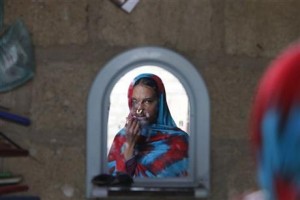 In this photo taken on Jan. 27, 2016, Pakistani acid victim Sidra Kamwal looks herself in a mirror in Karachi, Pakistan. Sidra’s attacker is in jail, but his family has been embraced by the neighbors. The family jeers at her, and the neighbors applaud. Sidra, with her painfully disfigured face, is the outcast.(AP Photo/Shakil Adil)