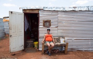 A woman sits outside her makeshift home in the squatter camp in Munsieville, a township in the Krugersdorp area in Gauteng Province 