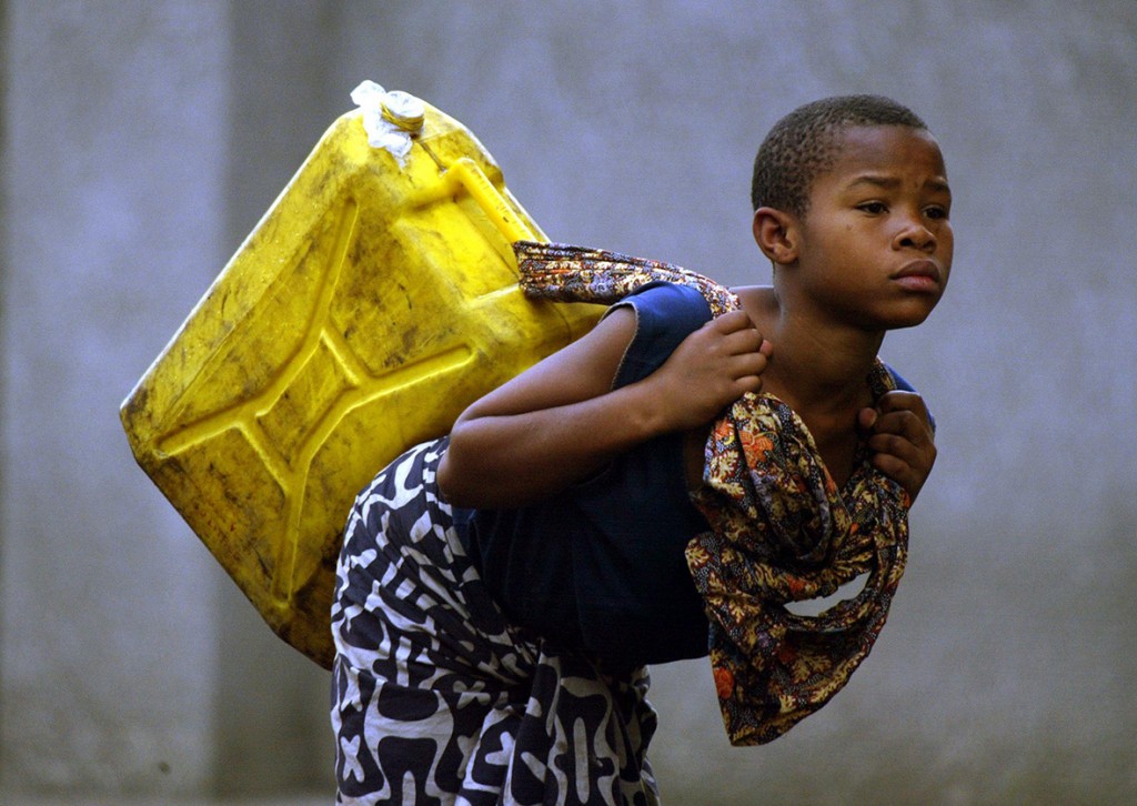 25 January 2002: A girl carries potable water to her home in GomaPedro Ugarte/ AFP