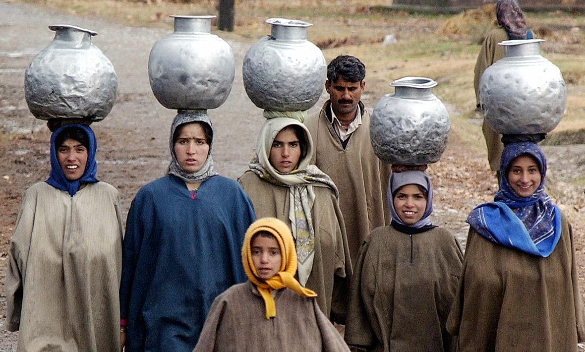 2 December 2004: Indian Kashmiri girls carry water pots on their heads in the outskirts of Srinagar, KashmirSajjad Husaain/ AFP