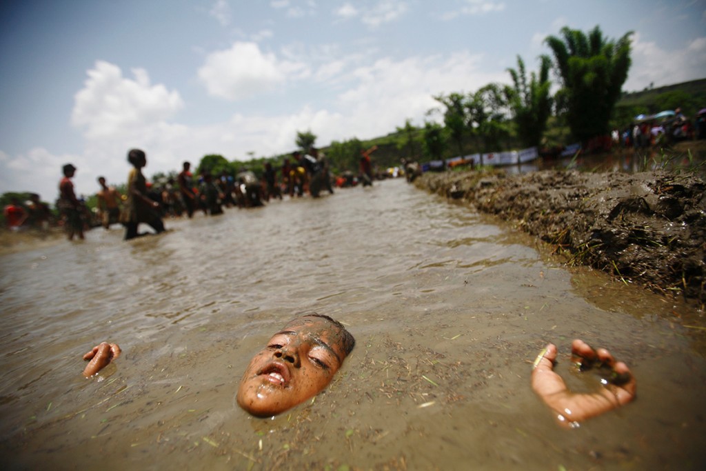 29 June 2012: A boy lies in muddy water in Pokhara valley, west of Nepal's capital KathmanduNavesh Chitrakar/ Reuters
