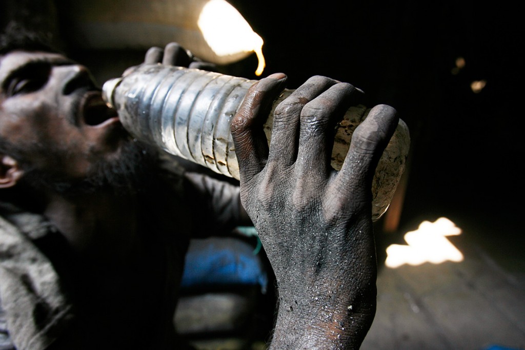 28 November 2007: An Indian labourer drinks water at an aluminium reprocessing unit in Dharavi, Asia's largest slums in MumbaiArko Datta/ Reuters