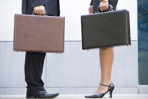 Two businesspeople holding briefcases outdoors