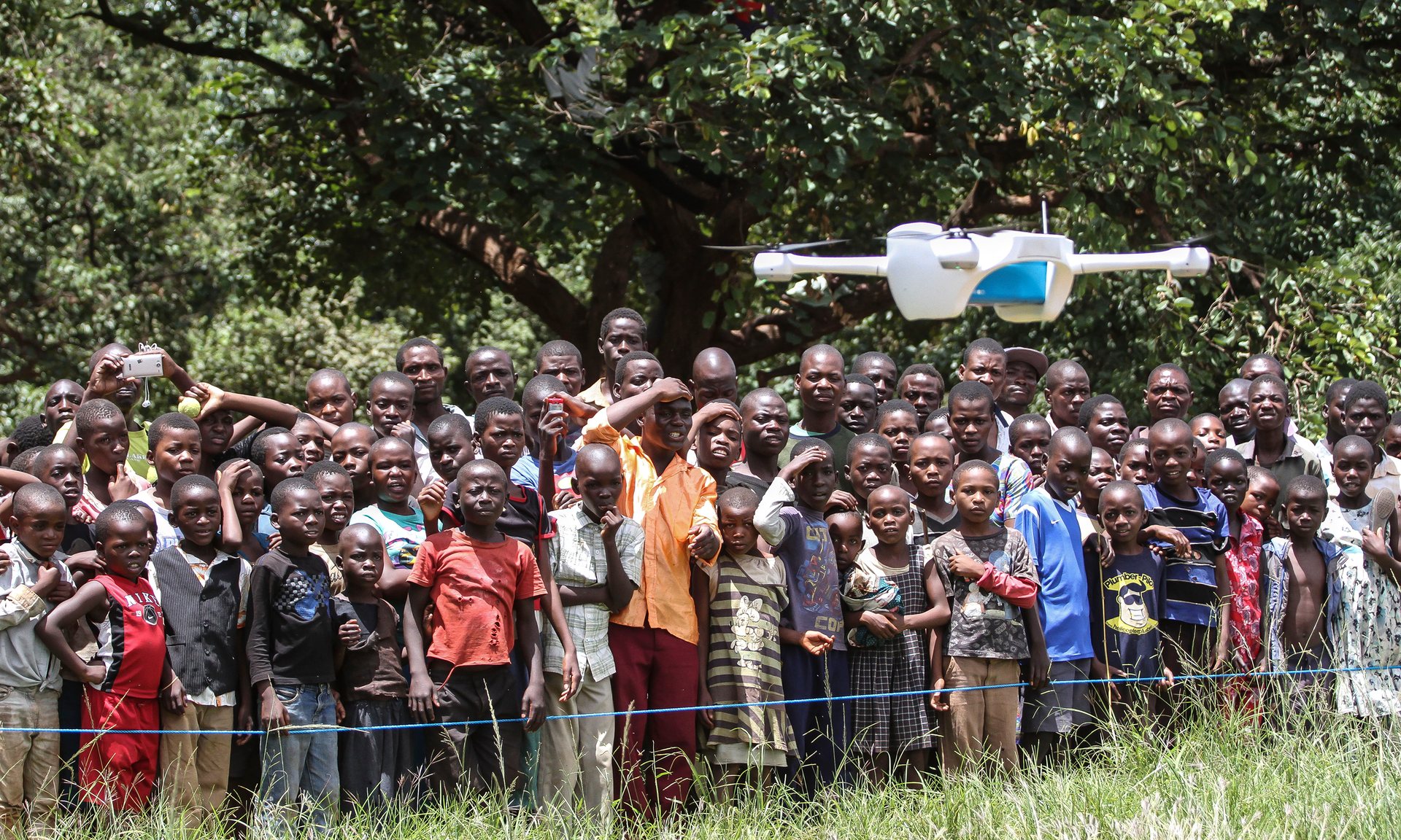 Children look on in astonishment as a drone is put through its paces at a community demonstration in Lilongwe. The Malawian government could use drones to reduce waiting times for medical tests. Photograph: Bodole/Unicef