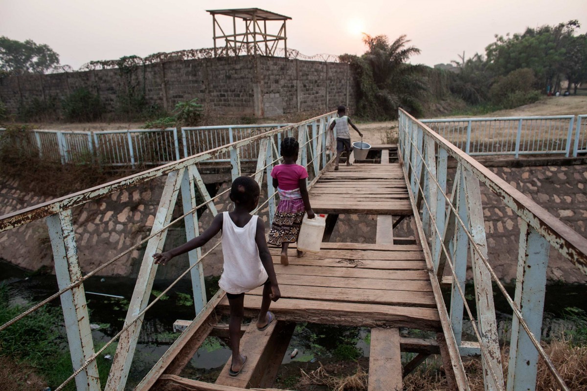 Children cross a dilapidated bridge outside the peacekeeper base near Castors in Bangui, Central African Republic. Photos by Jane Hahn