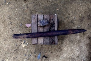 A stone and stick used for breast ironing are seen on a stool outside survivor of breast ironing Julie Ndjessa's home in Douala, Cameroon, November 4, 2013. The stick is mainly used as for preparing food. New government research shows that 'breast ironing,' where the breasts of young girls are flattened using a hot stone, has seen a 50 percent decline since it was first accidentally uncovered during a 2005 survey by the German Technical Cooperation Agency (GTZ) on rape and incest in Cameroon. Picture taken November 4, 2013. REUTERS/Joe Penney (CAMEROON - Tags: HEALTH SOCIETY) - RTX174CX