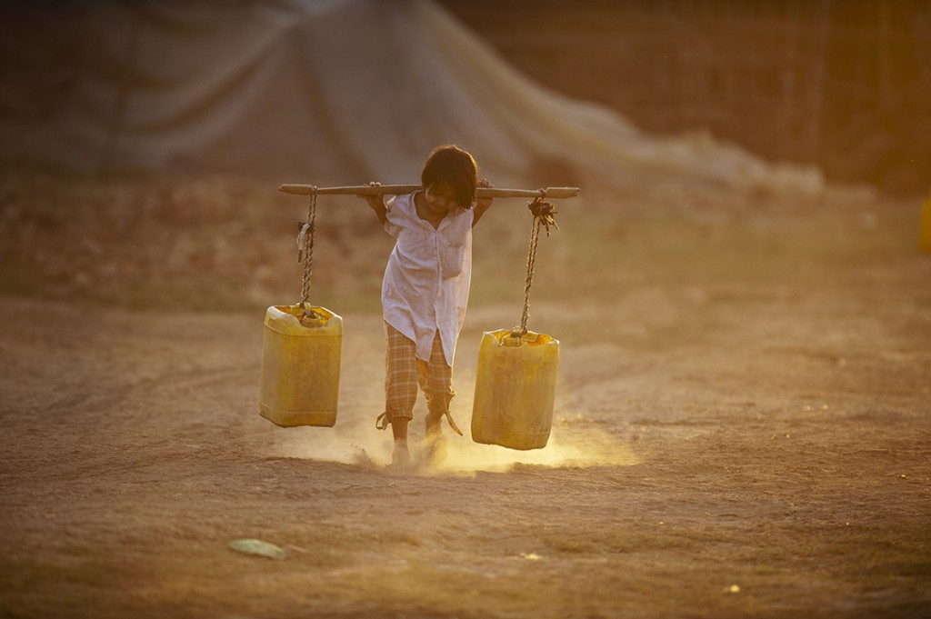  A child carries water home through a brick factory on the outskirts of Yangon Myanmar once known as the 'rice bowl of Asia' because of its agricultural richesYe Aung Thu/ AFP