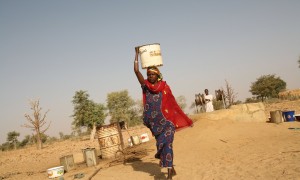 In Nigeria, a woman returns home with water from a well. Photograph: Suzanne Porter/Alamy