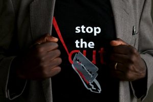 A man shows the logo of a T-shirt that reads "Stop the Cut" referring to Female Genital Mutilation (FGM) during a social event advocating against harmful practices such as FGM at the Imbirikani Girls High School in Imbirikani, Kenya, April 21, 2016. REUTERS/Siegfried Modola