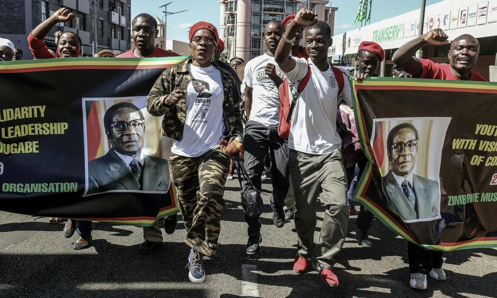 Supporters of Zimbabwean president Robert Mugabe cheer during the march. Photograph: Jekesai Njikizana/AFP/Getty Images