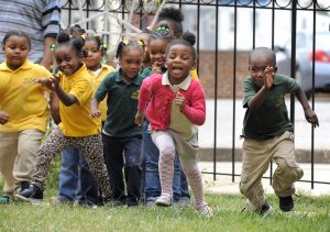Children at the Little Flowers Child Development Center romp on the playground. Their teachers like to get them outsidein the sunshine to exercise, which helps them to focus later in the classroom.