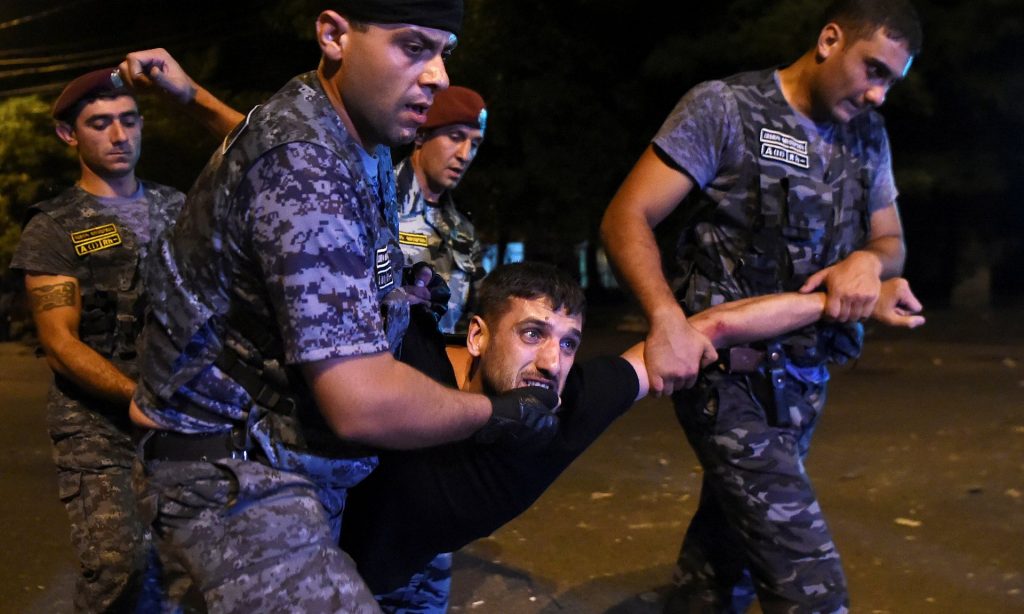 Police officers detain a protesters during demonstration in Yerevan Photograph: Reuters