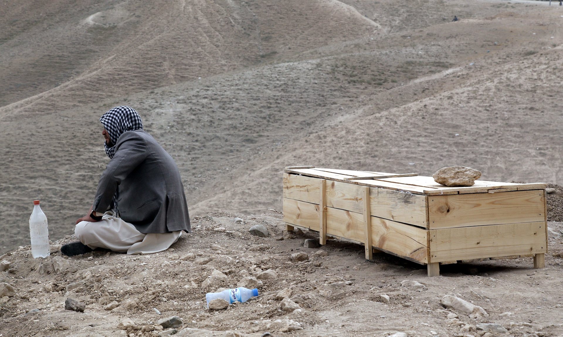 A man sits beside the coffin of his relative who was killed in a suicide bomb attack in Kabul, Afghanistan. Photograph: Jawad Jalali/EPA