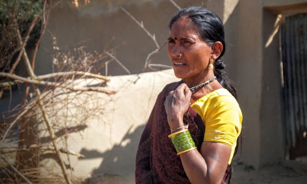 Nirupabai, a Kawar Adivasi woman, stands next to her home which was demolished nine days later in February 2014 for the expansion of the Kusmunda mine. Her belongings, including a year’s worth of grain, were destroyed in the evictions, January 2014. 