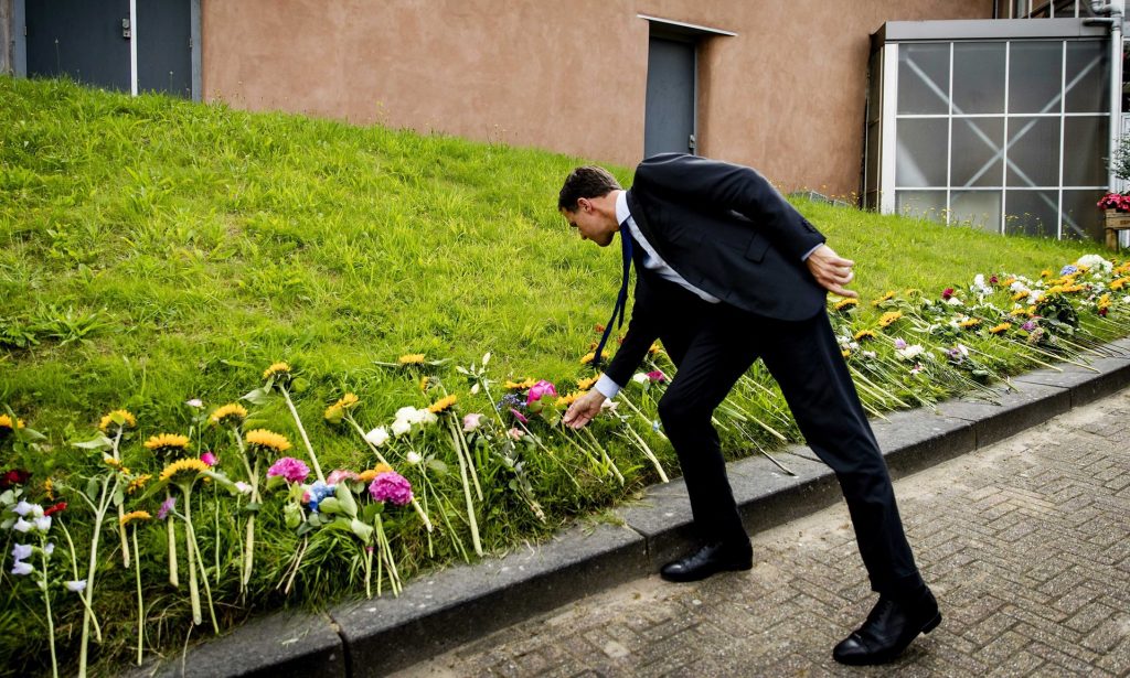 The Dutch prime minister Mark Rutte lays a flower on his departure from the Expo Haarlemmermeer in Vijfhuizen, Netherlands, on Sunday. Photograph: Robin van Lonkhuijsen/EPA