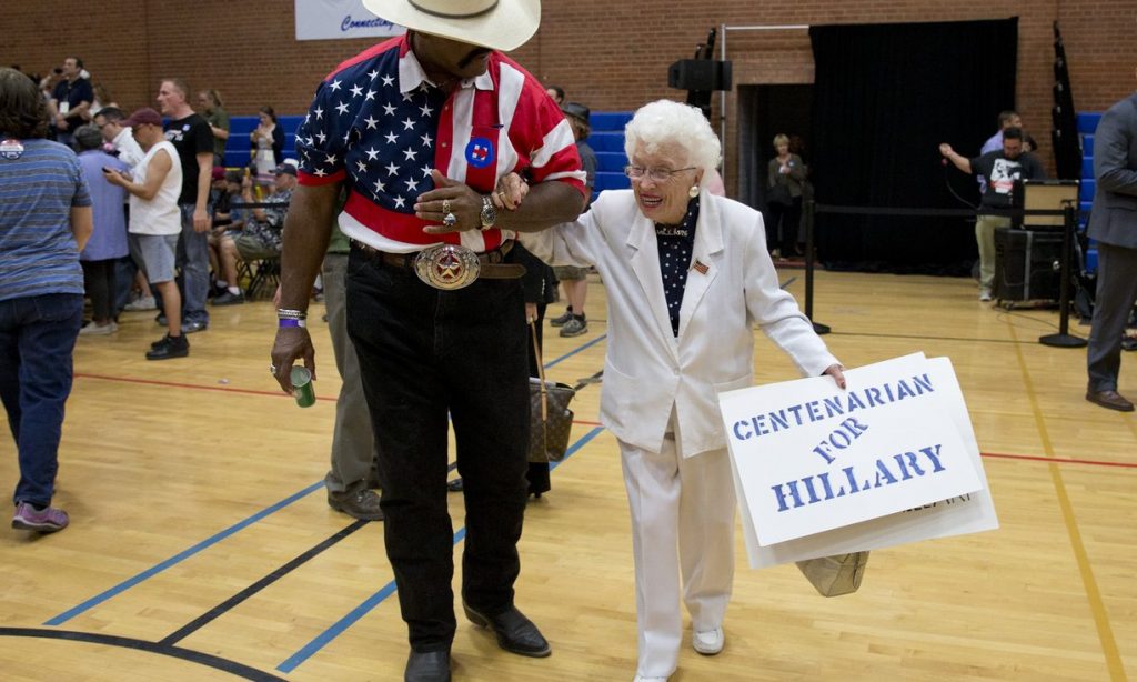 John Goodie escorts Jerry Emmett, a Hillary Clinton supporter, to her seat before Clinton arrives to speak at a campaign event at Carl Hayden Community High School in Phoenix on 21 March 2016. Photograph: Carolyn Kaster/AP