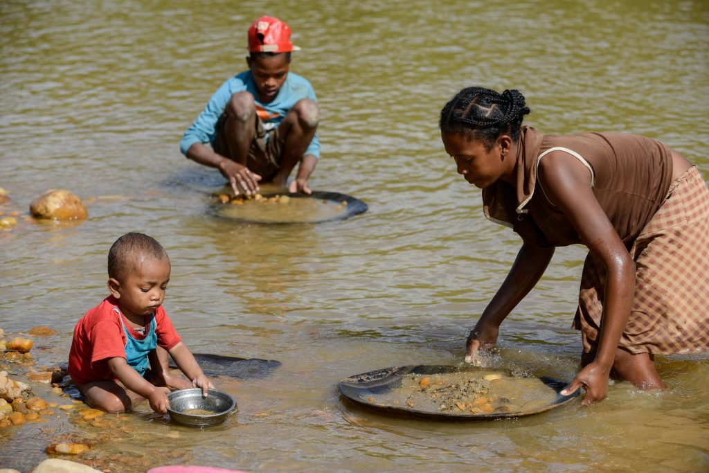 Children and a woman pan for gold in the river near the Madagascan city of Mananjary, June 2015. Photograph: Joerg Boethling/Alamy