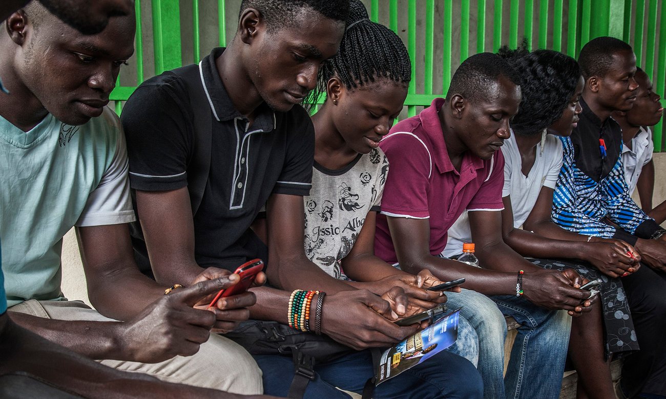 Travellers consult their mobile phones in Abidjan, Ivory Coast. The number of smartphones in Africa is set to triple over the next five years Photograph: Bloomberg/Bloomberg via Getty Images 