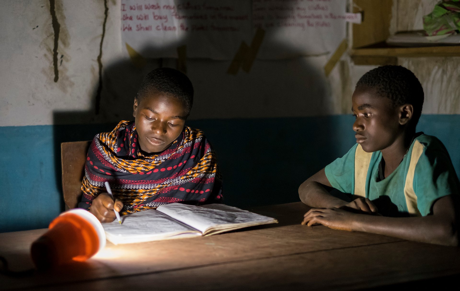 Pupils prepare for exams at night, using solar lamps, in Gumbi library