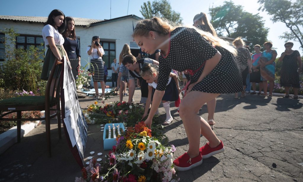 Local villagers lay flowers near pictures of the passengers on flight MH17 flight at a makeshift memorial in Petropavlivka village in eastern Ukraine on Sunday. Photograph: Aleksey Filippov/AFP/Getty Images