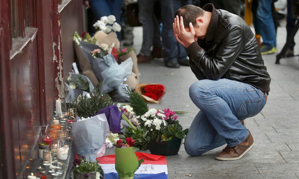 A man pays his respects outside the Le Carillon restaurant the morning after the attacks in Paris in November. Photograph: Christian Hartmann/Reuters