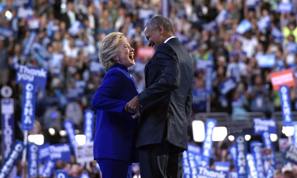 Barack Obama stands with Hillary Clinton after her surprise appearance onstage. Photograph: Susan Walsh/AP