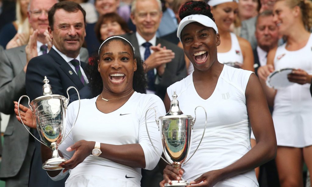 Serena Williams, left, and her sister Venus show off their trophies after they won the Wimbledon women’s doubles title. Photograph: Justin Tallis/AFP/Getty Images
