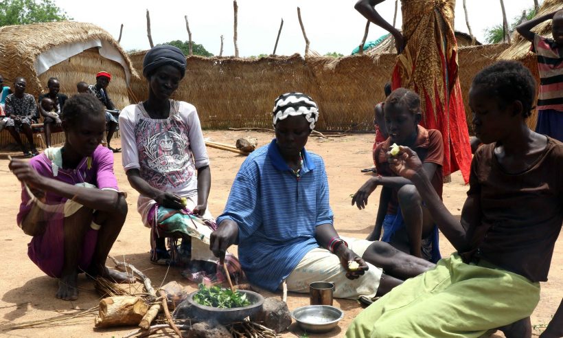 Ajak Adong (middle) cooks leaves for her family in the border town of Kiir Adem, where she has been stranded for two months. Severe food insecurity in the region of Northern Bahr el Ghazal has forced tens of thousands to migrate to Sudan. Photograph: Simona Foltyn