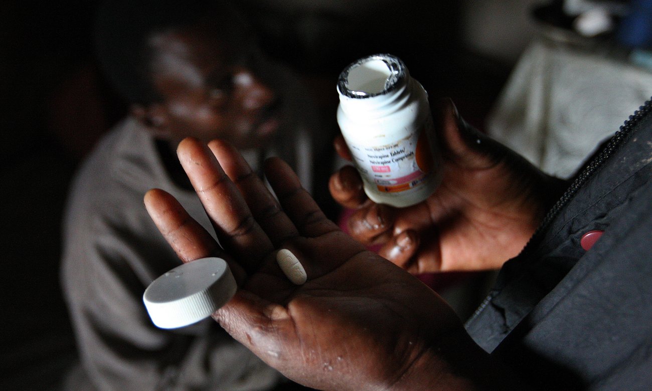  A woman hands an anti-retroviral tablet to her husband in Mkhulamini, photographed in 2009. Photograph: Jon Hrusa/EPA 