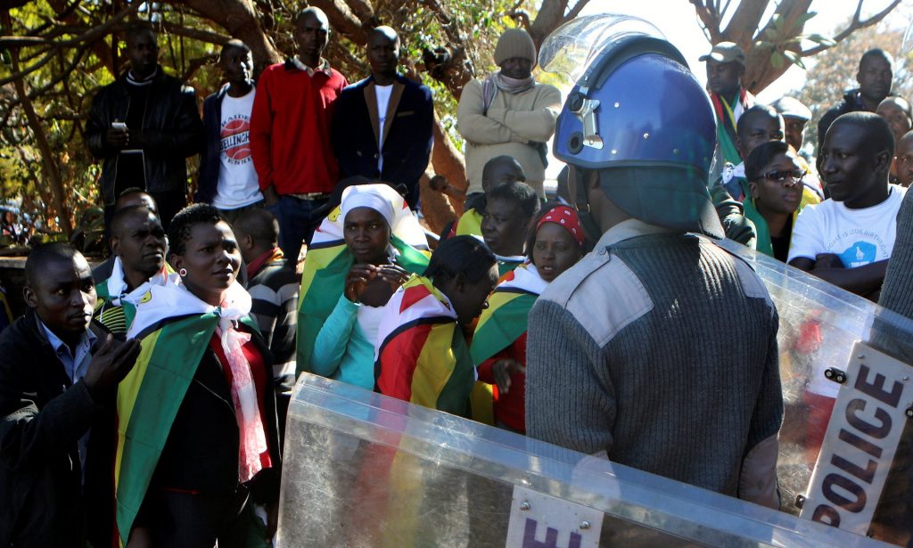 Riot police and anti-government activists in Harare as tensions in the country remain high. Photograph: Philimon Bulawayo/Reuters