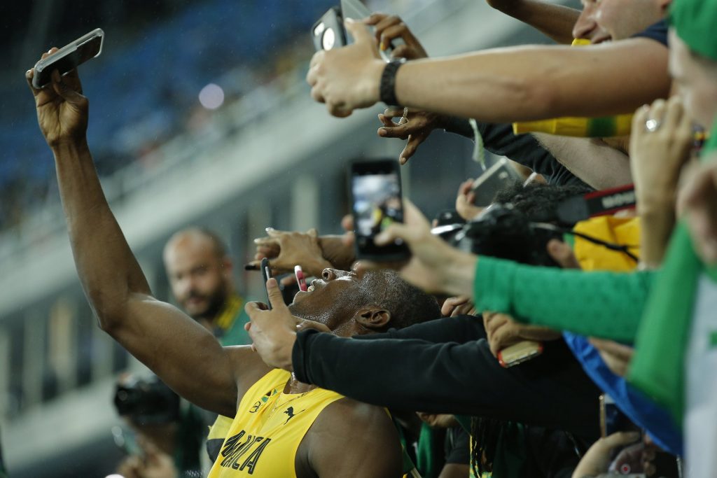 Usain Bolt, ever the crowd pleaser, takes selfies with his fans. Photograph: Tom Jenkins for the Guardian