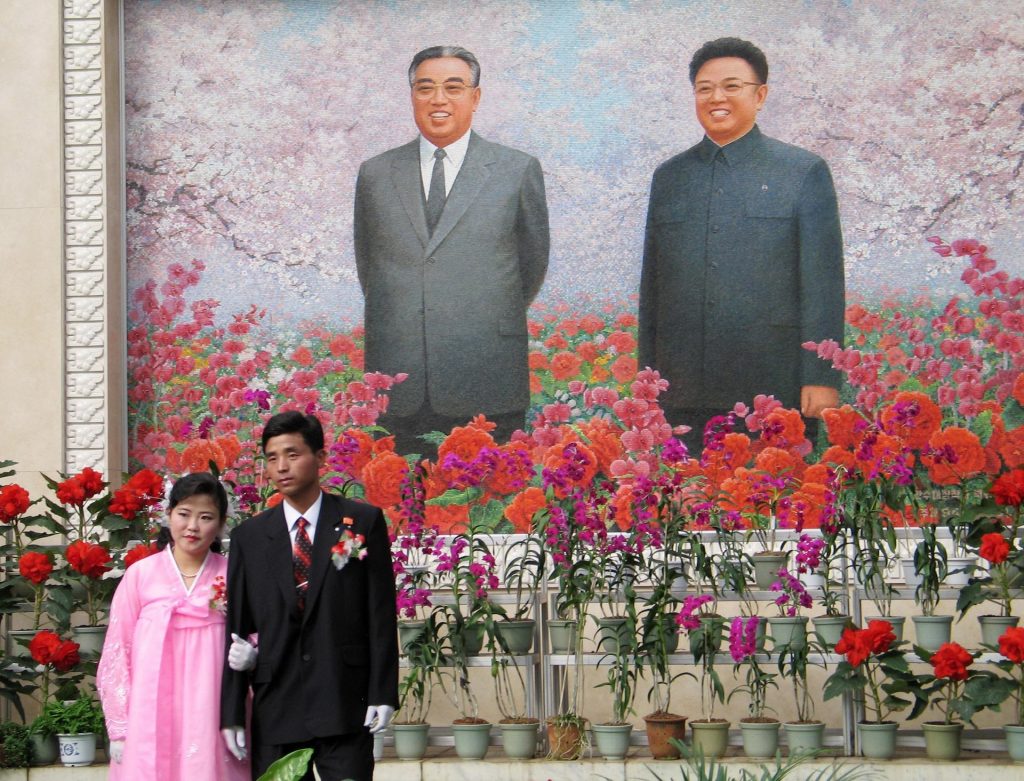 A couple pose in front of the country’s founder Kim Il-Sung and his more romantic son Kim Jong-il Photograph: Reuters