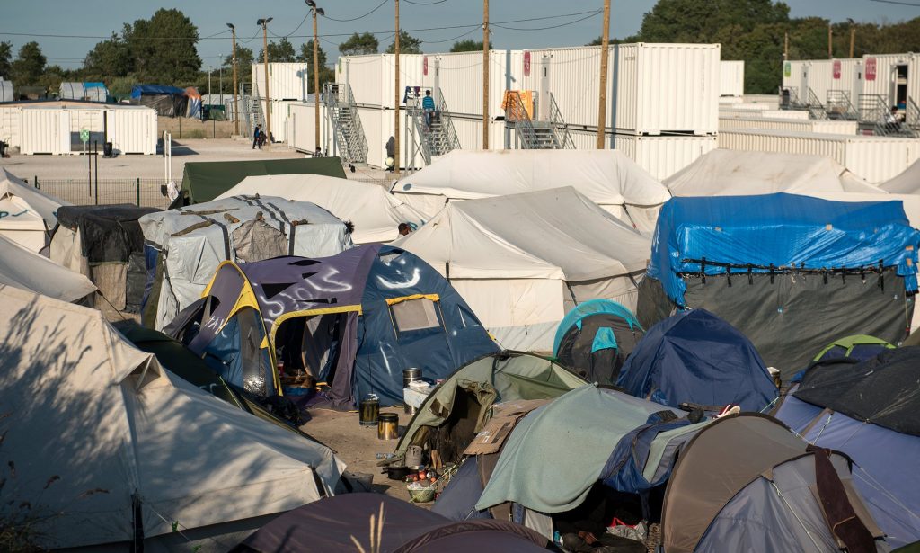 The tents and white metal containers housing refugees in Calais. Photograph: Alecsandra Raluca Drăgoi for the Guardian