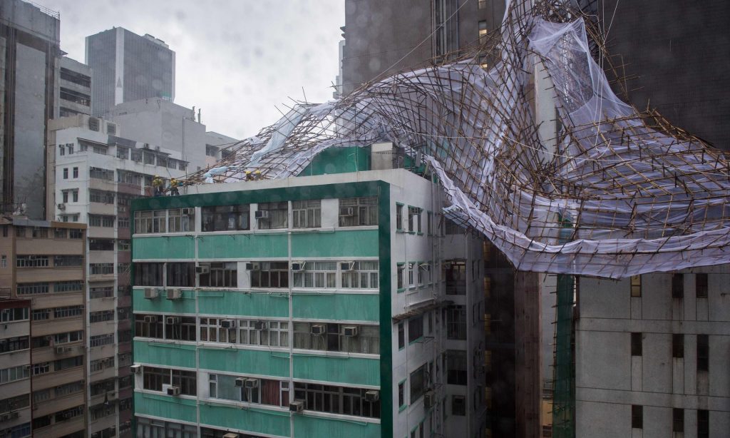 Rescue workers attempt to secure bamboo scaffolding that was damaged overnight at the top of a building in Hong Kong during Typhoon Nida. Photograph: Anthony Wallace/AFP/Getty Images