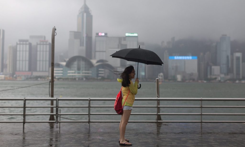 A woman stands on the Victoria Harbour waterfront during Typhoon Nida in Hong Kong. Photograph: Jerome Favre/EPA