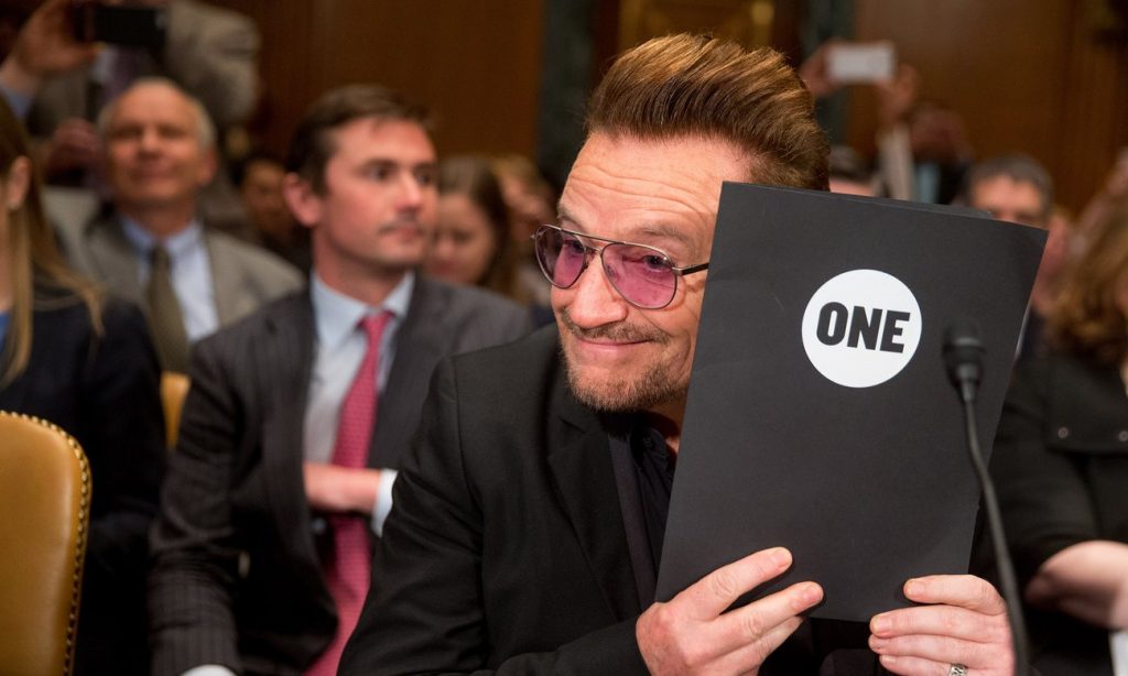 Irish rock star and activist Bono holds up a folder with the logo of One, the advocacy organisation he co-founded, which works to end extreme poverty and preventable disease. Photograph: Andrew Harnik/AP
