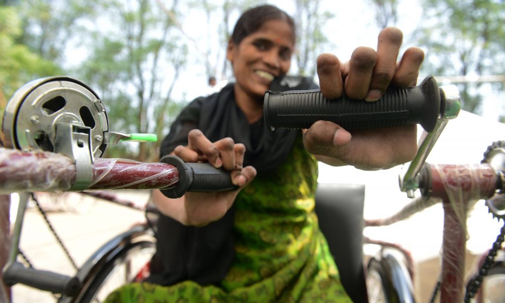 A woman smiles after receiving a mobility tricycle in Secunderabad, India. Photograph: Noah Seelam/AFP/Getty