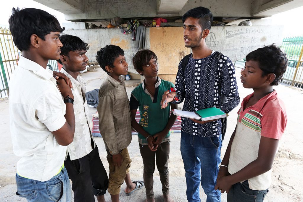 Sourav meets with new street children and explains to them how the newspaper works and how to report injustices they witness. (Showkat Shafi/Al Jazeera)