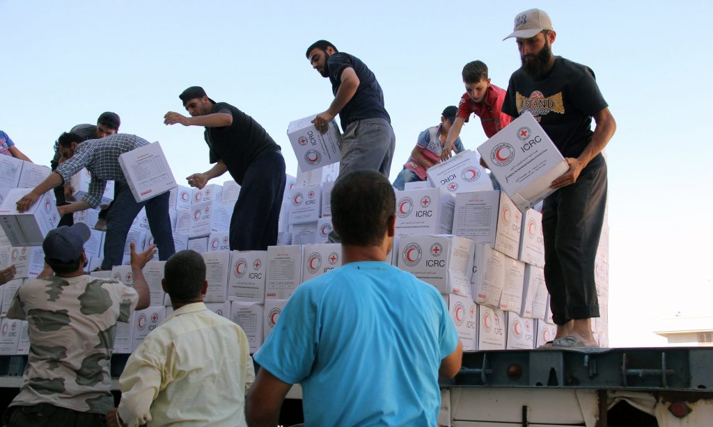 Syrians unload boxes after a 48-truck convoy from the ICRC, SARC and UN entered the Syrian rebel-held town of Talbiseh. Photograph: Mahmoud Taha/AFP