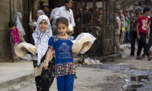 Syrian girls outside a bakery in a rebel-held neighbourhood in Aleppo, July 2016. The city has suffered enormous destruction in a war that has killed 400,000 across Syria, according to the UN. Photograph: Karam Al-Masri/AFP/Getty Images