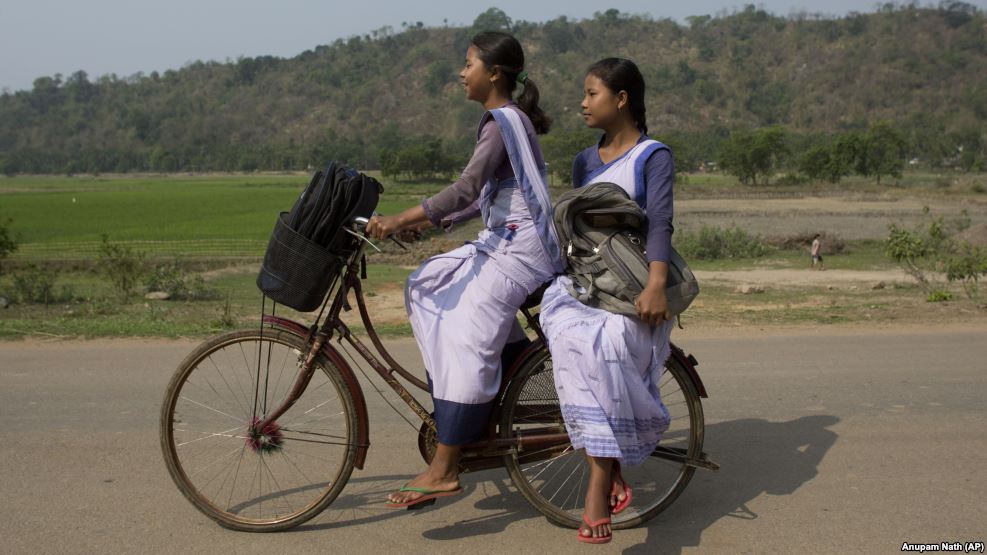 Indian girls go to a school on a bicycle at Roja Mayong village about 40 kilometers (25 miles) east of Gauhati, India