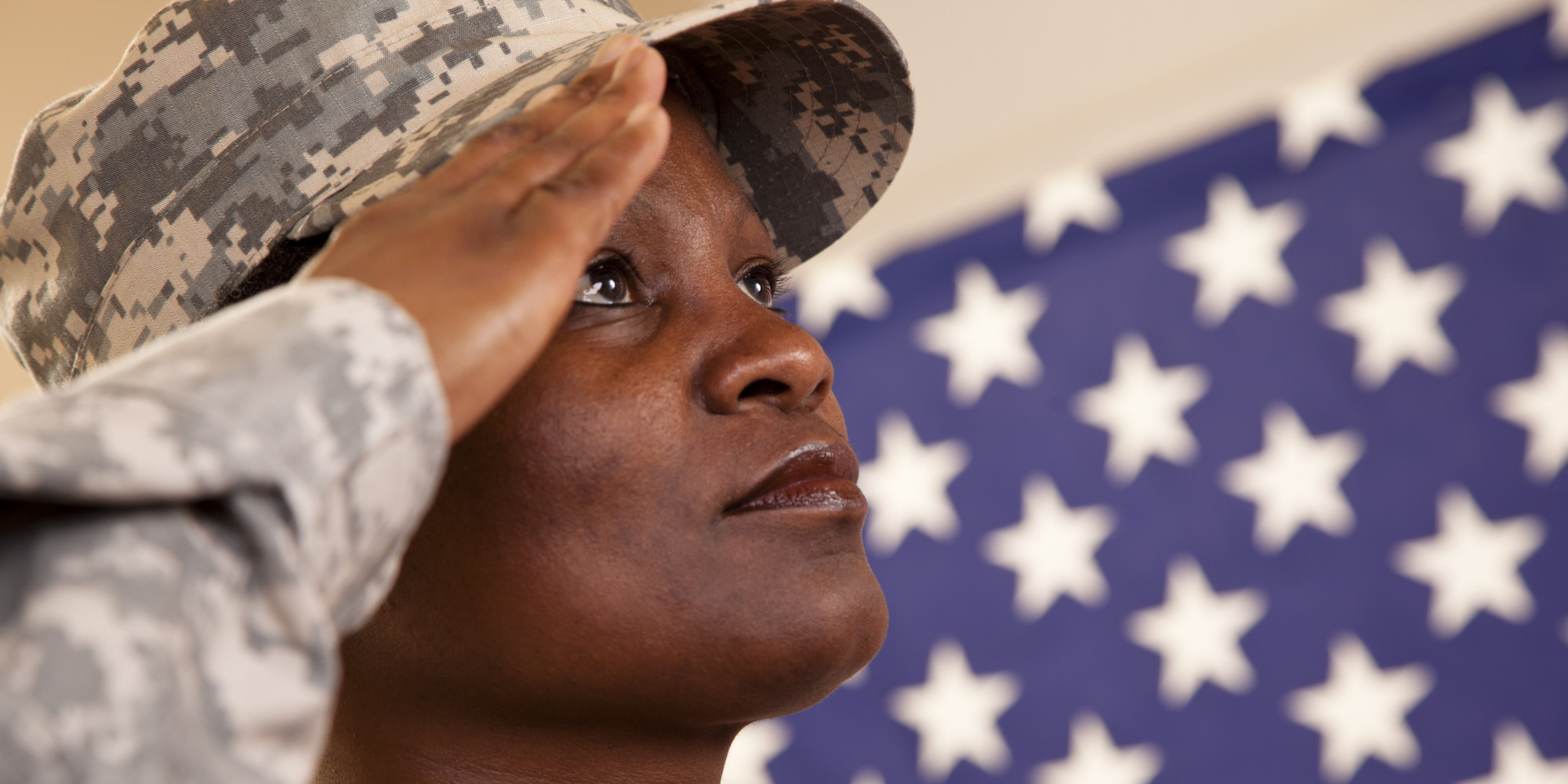 Patriotism: African descent military woman salutes American flag.