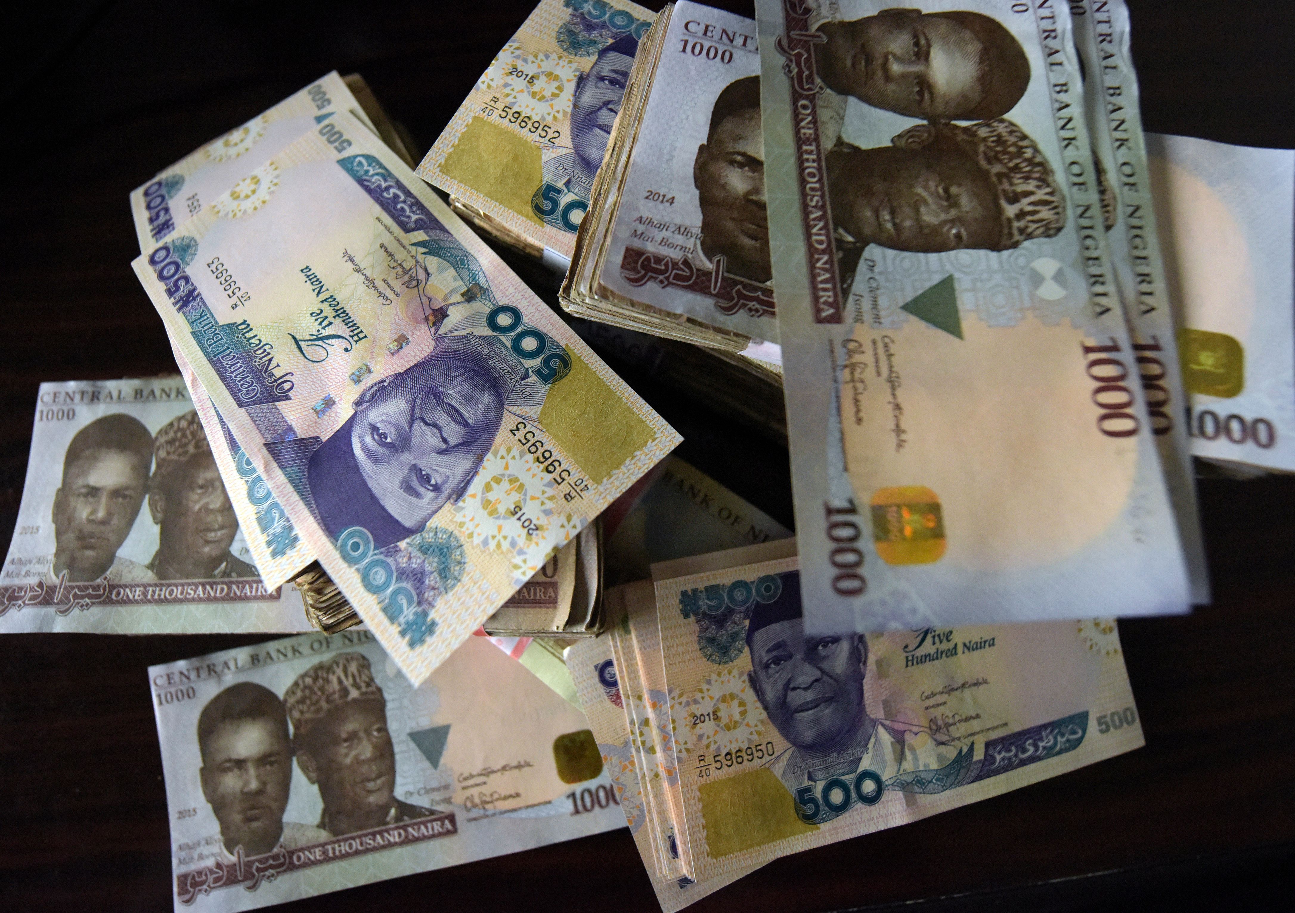 This picture taken on January 28, 2016 in Lagos shows naira banknotes, Nigeria's currency.  Nigeria's central bank governor, Godwin Emefiele, on January 26 dismissed calls to devalue the naira in his monetary policy committee statement. Instead he chose to continue propping up the currency at 197-199 naira to the dollar and maintain foreign-exchange restrictions. As a result, the naira on the black market is hovering around a record low of 305, fuelling complaints from domestic and foreign businesses who can't access dollars required for imports.  / AFP / PIUS UTOMI EKPEI        (Photo credit should read PIUS UTOMI EKPEI/AFP/Getty Images)