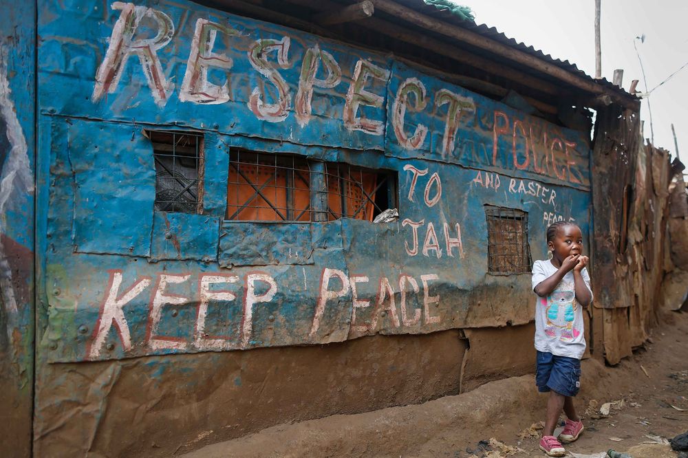 A young girl walks in front of a pub decorated with messages of peace painted during the 2007-08 general elections in Kenya—where post-election violence killed more than a thousand people—in Kibera slum, one of opposition leader Raila Odinga’s strongholds in the capital Nairobi, in July 2017. Photographer: DAI KUROKAWA/EPA/Redux