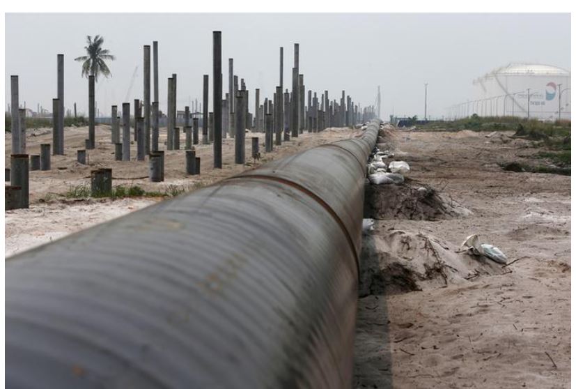 An oil pipeline is laid next to the Vopak-Dialog oil storage facility (R) and a Refinery and Petrochemical Integrated Development (RAPID) project construction site in Pangerang in Malaysia's southern state of Johor October 6, 2015. Edgar Su/File Photo