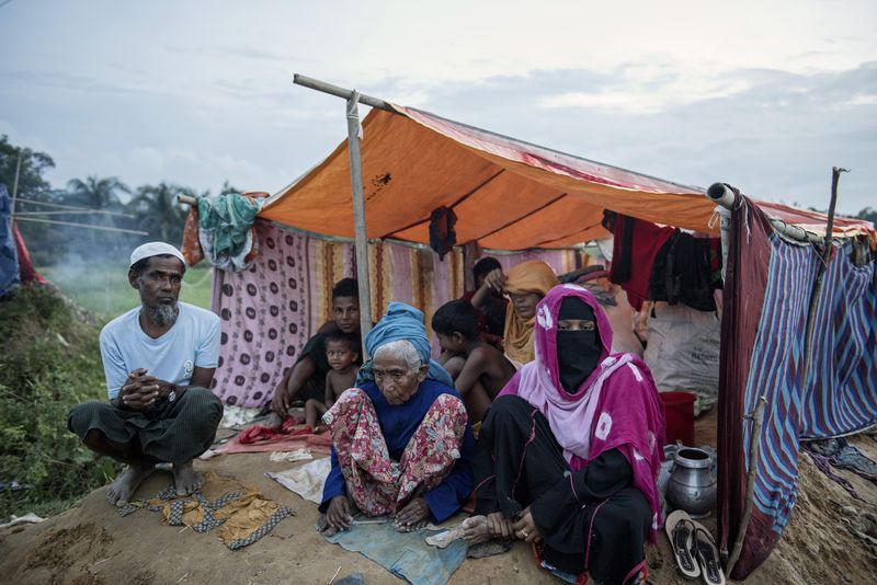 A Rohingya family sits under a makeshift tent at a refugee camp in Cox’s Bazar, Bangladesh. Photographer: Ismail Ferdous/Bloomberg