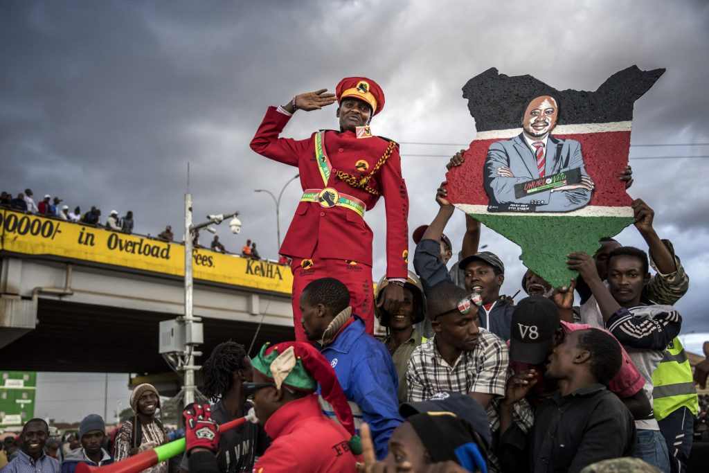 A supporter of Kenya’s president Uhuru Kenyatta salutes from a crowd in Nairobi on Monday, Oct. 23, 2017. Photographer: Luis Tato/Bloomberg